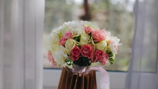A festive bouquet of fresh flowers stands on the windowsill. To the left and right of the bouquet is tulle