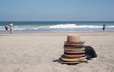 pile of hats by the beach on a sunny day.