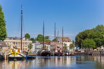 Fototapeta na wymiar Historic ships and old houses in the harbor of Gouda, Netherlands