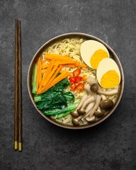 Asian Style Noodles Soup with Mushrooms, eggs, dan Assorted Vegetables on the dark background.