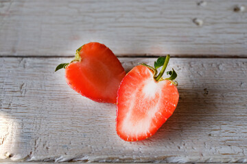 One red strawberry sliced on wood background.,close up