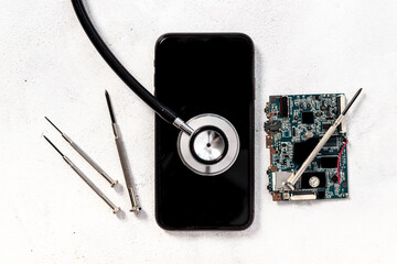 Fototapeta na wymiar Repairing electronics circuit board - mobile phone with microchips