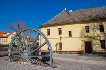 Obraz premium Industrial wheel and coal carts in front of a historic building in Eisleben, Germany