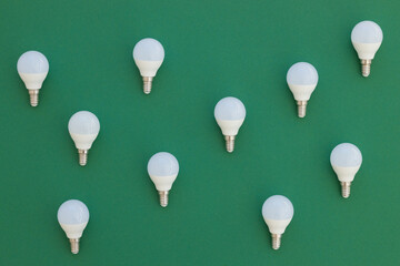 LED light bulb lies on a pastel green background. Energy saving concept. Minimalism, top view