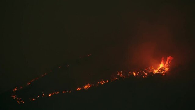 Wildfire burning at night on hillside in Utah during the summer heat.