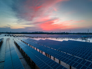 Obraz premium Solar power station at beautiful sunset. solar photovoltaic power station on water. green energy concept.