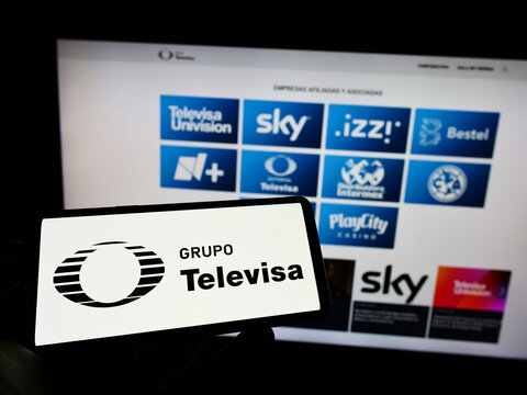 Stuttgart, Germany - 06-19-2022: Person holding mobile phone with logo of Mexican media company Grupo Televisa S.A.B. on screen in front of web page. Focus on phone display.