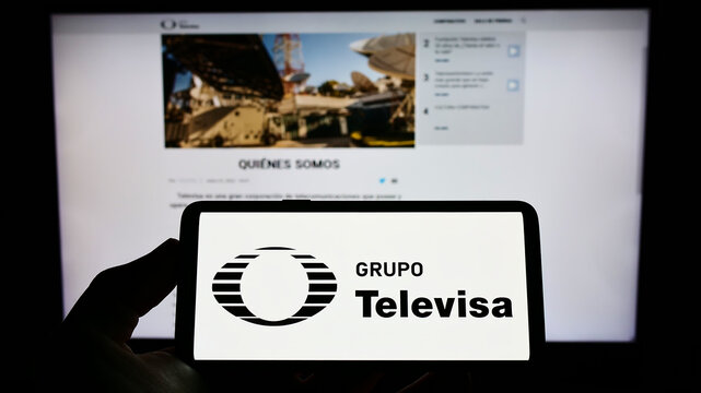 Stuttgart, Germany - 06-19-2022: Person holding cellphone with logo of Mexican media company Grupo Televisa SAB on screen in front of business logo. Focus on phone display.