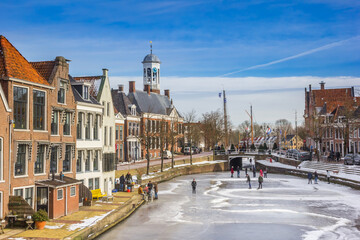 Old houses and town hall in a typical dutch winter scene in The Netherlands