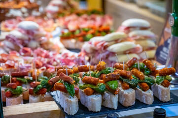 Typical snack of Basque Country and Navarre, pinchos or pinxtos, small piece of bread with different toppings, served in bar, Bilbao, Spain