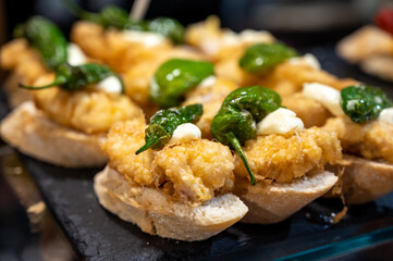 Typical snack of Basque Country and Navarre, pinchos or pinxtos served in bar, small slices of bread upon which ingredient or mixture of ingredients is placed, San Sebastian, Spain