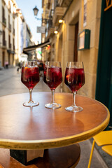 Glasses of cold sangria wine served outdoor in bar with view on old street in San Sebastian, Basque Country, Spain