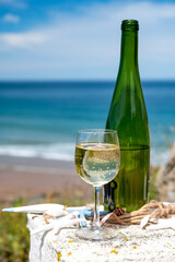 Txakoli or chacolí slightly sparkling very dry white wine produced in the Spanish Basque Country, served outdoor with view on Bay of Biscay, Atlantic Ocean.