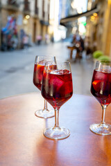 Glasses of cold sangria wine served outdoor in bar with view on old street in San Sebastian, Basque Country, Spain