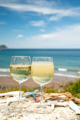Tasting of txakoli or chacolí slightly sparkling very dry white wine produced in the Spanish Basque Country, served outdoor with view on Bay of Biscay, Atlantic Ocean.