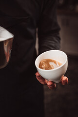 The work of a barista in a cafe close-up - the stages of preparing aromatic coffee - the process of work