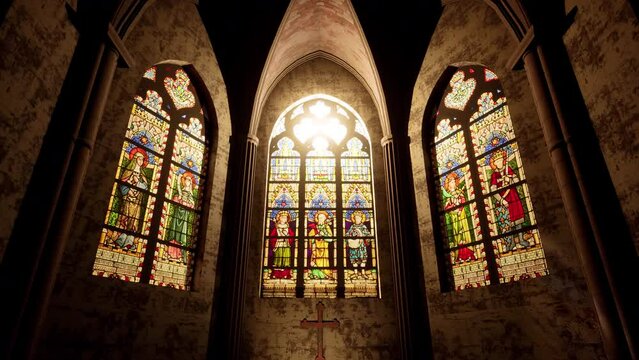 The light of the sun beaming in through the stained glass windows of a Church.