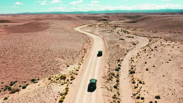 convoy of sleek black SUVs cruising along an empty country road or the dusty expanse of a desert. The powerful machines exude an air of authority and luxury, 