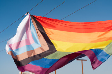 A lgbt flag hanging in the wind on a rooftop, freshly washed ready for use.