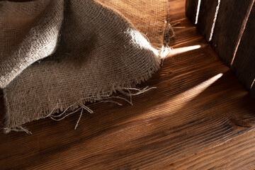 Burlap on rustic wood in a barn with reflections of light. 