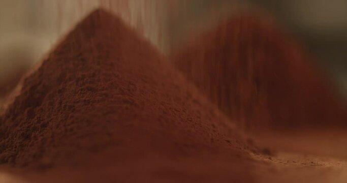 Cocoa powder is pouring onto the mountain of cocoa