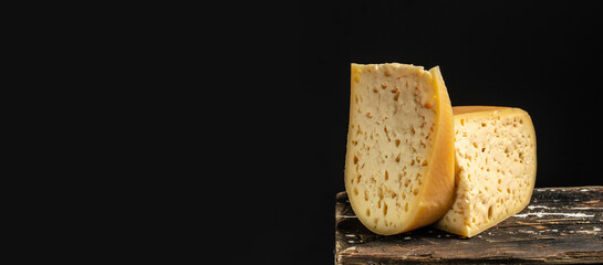 Emmental cheese triangle, Swiss cheese on a dark background. Long banner format