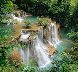 Beautiful waterfall in the tropical jungle at Kanchanaburi, Thailand. Emerald green waters in the...