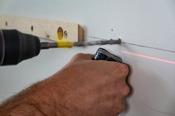 Stockholm, Sweden A carpenter drills a hole in a concrete wall with the help of a laser (for...