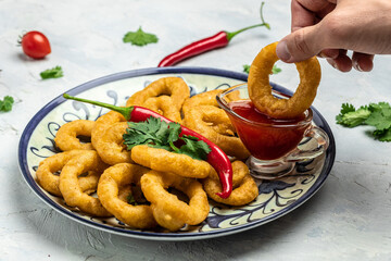 Rings of squid with lemon and sauce on a light background. Snack to beer. banner, menu, recipe place for text, top view