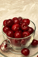 red ripe cherries in a teacup on the table