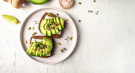 Healthy avocado toasts with rye bread, sliced avocado, cheese, pumpkin, nut and sesame for breakfast or lunch. Vegetarian food. Vegan menu. Food recipe background. Close up - obrazy, fototapety, plakaty