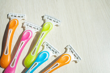 razors of different colors for women on a light background, with a place for text. Beauty, care,...