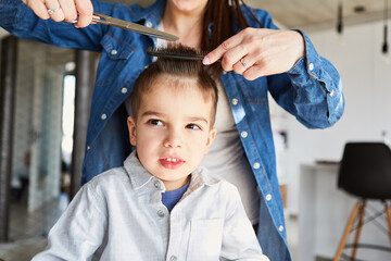 Mutter oder Friseur beim Haare schneiden von Kind