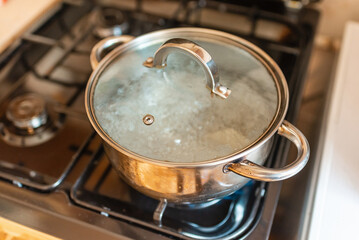 Boiling water inside a pot.Kitchen iron pot,top view,selective focus.