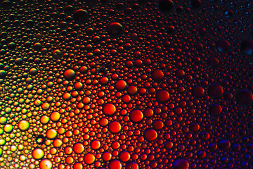 Oil and water bubbles to create different size of bubbles in this art image created by the addition of red-orange coloured lighting effects background.