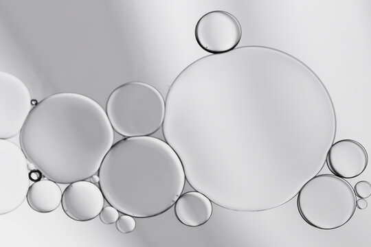 Water and oil droplets to creating circle and bubbles shape on grey greadient background.