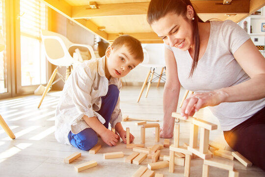 Mutter und Kind spielen zusammen mit Bausteinen
