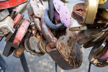 Metal padlocks on the fence of the bridge as a symbol of eternal love close-up