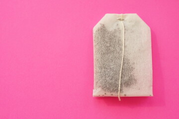 Tea bag on vivid pink table, copy space