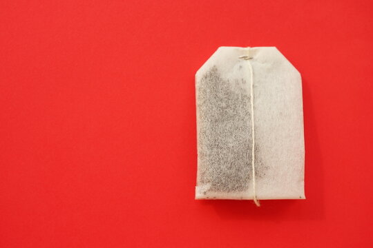 Tea bag on red table, copy space