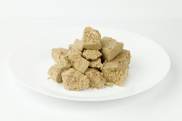 Pieces of sweet halva on a white plate, oriental sweets.