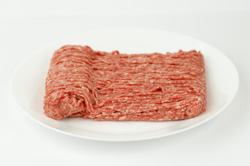 Fresh ground beef on a white plate, minced pork.