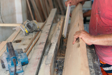 Carpenter's hands organizing the wood before starting the job.