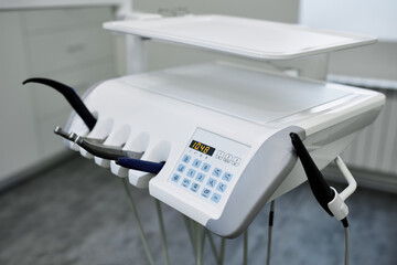 Dental equipment in the office of a dentist doctor with gray walls against the backdrop of bright light from the window.