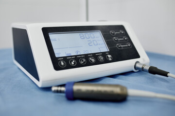 Dental equipment in the office of a dentist doctor with gray walls against the backdrop of bright light from the window.