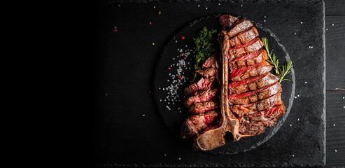 Dry Aged Barbecue Porterhouse Steak T-bone beef steak sliced with large fillet piece with herbs and...