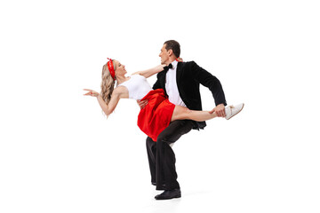 Excited young couple of dancers in vintage retro style outfits dancing social dance isolated on white background. Art, music, fashion, style concept