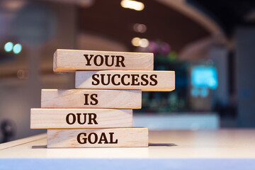 Wooden blocks with words 'Your success is our goal'. Business concept