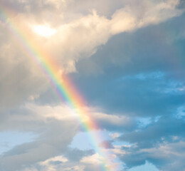 amazing bright rainbow in beautiful evening cloudy sky after rain and thunder, weather concept