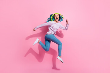 Full body photo of sporty overjoyed lady jump running rush fast have good mood isolated on pink color background